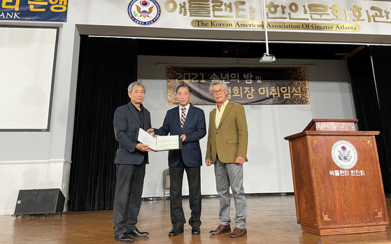 김윤철(가운데)회장이 지난달 30일 오후 노크로스에 있는 애틀랜타 한인회관에서 배기성 인수위원장에게 한인회관 열쇠 및 체크북을 전달했다. 이 체크북의 계좌는 잦은 부도수표 발행으로 인해 이달 초 사용 중지(closed)된 것으로 알려졌다. 