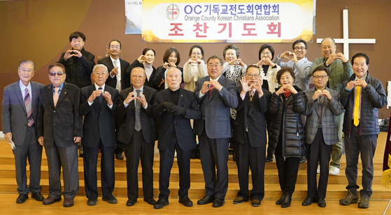 OC기독교전도회연합회 조찬기도회 참석자들이 손으로 하트 모양을 만들어 보이고 있다. ［연합회 제공］               