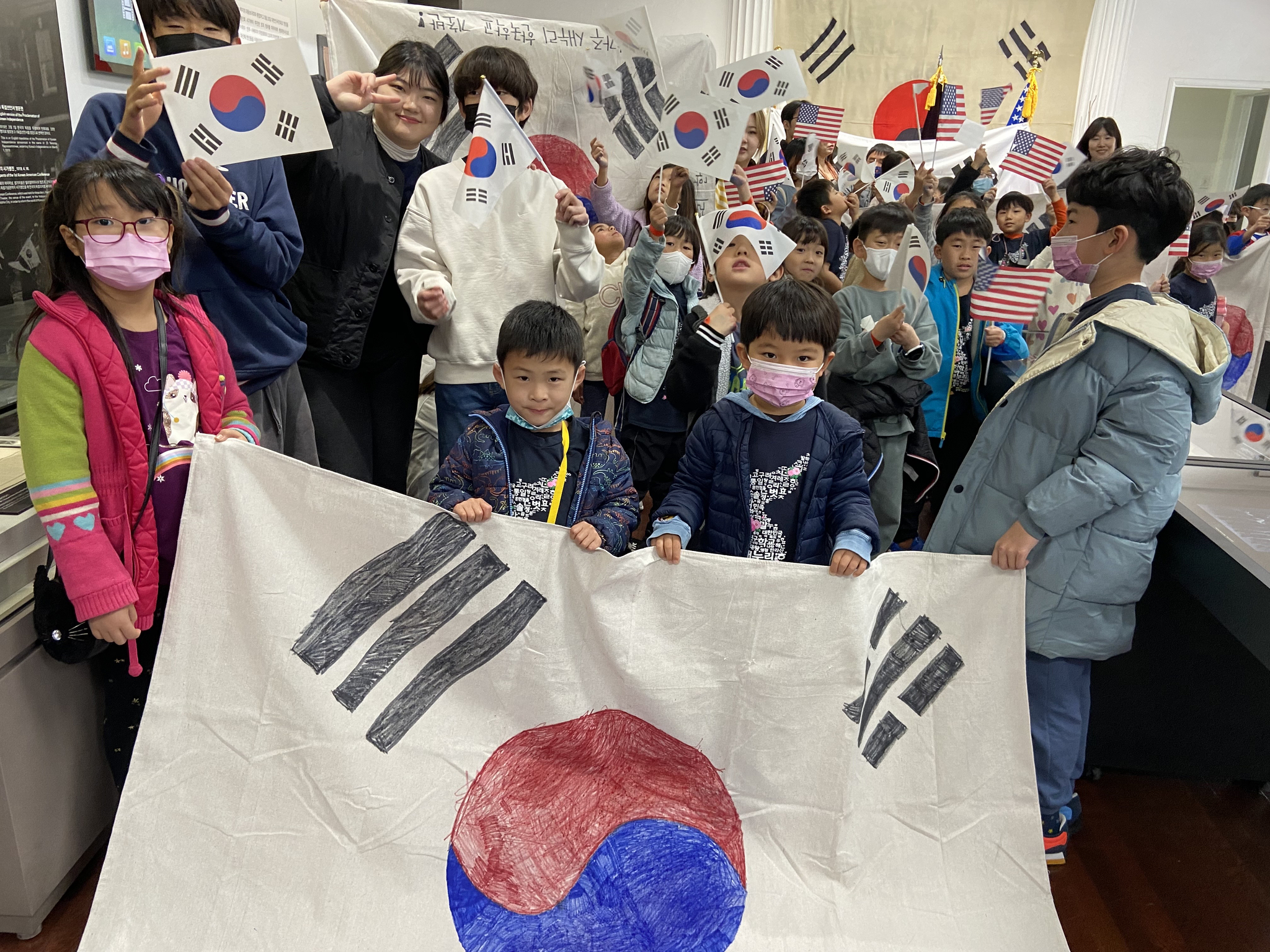 지난 5일 대한인국민회 전시관을 방문한 새누리교회 한글학교 학생들이 대형 태극기를 들고 활짝 웃고 있다. [대한인국민회 제공]