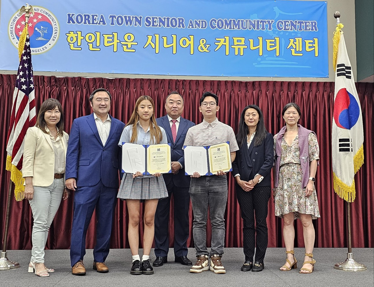 한인 커뮤니티 변호사협회 류영욱 회장(중간)이 학생 봉사자들에게 장학금을 전달하고 있다. [시니어센터 제공] 