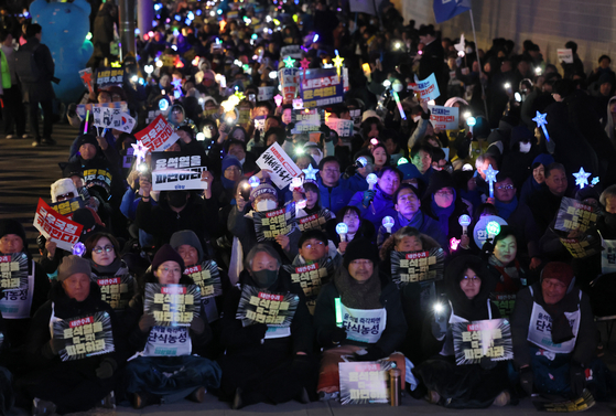 지난19일 서울 종로구 동십자각 앞에서 열린 '내란수괴 윤석열 즉각 파면 긴급행동'에서 참석자들이 윤 대통령의 탄핵을 촉구하고 있다. 연합뉴스